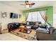 Inviting living room with a ceiling fan, black leather couches, and a leafy decorative rug at 2548 Archfeld Blvd, Kissimmee, FL 34747