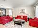 Bright living room with red sofas, a large rug, and ample natural light at 2548 Archfeld Blvd, Kissimmee, FL 34747