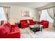 Bright living room with red sofas, a large rug, and ample natural light at 2548 Archfeld Blvd, Kissimmee, FL 34747