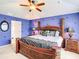 Main bedroom featuring dark wood furnishings, ceiling fan, and a decorated accent wall at 2548 Archfeld Blvd, Kissimmee, FL 34747