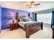 Main bedroom featuring dark wood furnishings, ceiling fan, and a decorated accent wall at 2548 Archfeld Blvd, Kissimmee, FL 34747