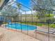 Enclosed pool with clear blue water, brick patio, and partial enclosure at 2548 Archfeld Blvd, Kissimmee, FL 34747
