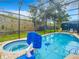 Enclosed pool and hot tub with clear blue water, brick patio, and partial enclosure at 2548 Archfeld Blvd, Kissimmee, FL 34747