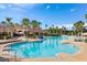 Large community pool surrounded by lounge chairs and palm trees, perfect for relaxation and recreation at 2548 Archfeld Blvd, Kissimmee, FL 34747