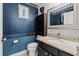 Charming half bathroom with granite countertop, decorative mirror, and unique wallpaper detail at 2630 Albion Ave, Orlando, FL 32833