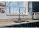 Close up of kitchen sink with granite countertops, stainless steel faucet, and white subway tile backsplash at 2630 Albion Ave, Orlando, FL 32833