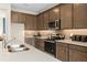 Spacious kitchen with wood cabinetry, under cabinet lighting, and stainless steel appliances at 2725 Serenity Garden Dr, Kissimmee, FL 34744