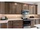 Modern kitchen with wood cabinets, stainless steel appliances, and light countertops at 2725 Serenity Garden Dr, Kissimmee, FL 34744
