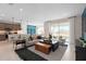 A living room features neutral colors, modern furnishings and decor, and open access to kitchen at 2725 Serenity Garden Dr, Kissimmee, FL 34744