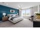 Modern main bedroom featuring an accent wall, contemporary lighting, and bright windows at 2725 Serenity Garden Dr, Kissimmee, FL 34744