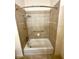 Tiled bathtub and shower combo featuring handrails and shower head at 2822 Bella Vista Dr, Davenport, FL 33897
