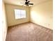 Bedroom with tan carpet, ceiling fan and window at 2822 Bella Vista Dr, Davenport, FL 33897