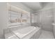 Bright bathroom featuring a relaxing soaking tub with jets and large window at 2930 Paddington Way, Kissimmee, FL 34747