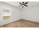 Cozy bedroom featuring hardwood floors, ceiling fan, and bright window at 2930 Paddington Way, Kissimmee, FL 34747