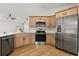 Bright kitchen with stainless steel appliances, light wood cabinets, and modern countertops at 2930 Paddington Way, Kissimmee, FL 34747