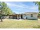 Back exterior view of home with a screened-in porch and a spacious lawn at 295 W Charlotte Ave, Eustis, FL 32726