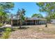 Home's backyard featuring a screened-in porch and spacious lawn at 295 W Charlotte Ave, Eustis, FL 32726