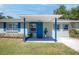 Welcoming front porch with a bright blue door, stylish planters, and charming curb appeal at 295 W Charlotte Ave, Eustis, FL 32726