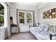 Bedroom with a metal frame daybed, neutral carpet, and natural light from two windows at 301 S Palmetto Ave, Sanford, FL 32771
