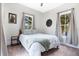 This bright bedroom has soft neutral décor, two windows and a small side table at 301 S Palmetto Ave, Sanford, FL 32771