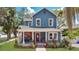 Charming two-story home with a blue facade, inviting front porch, and manicured lawn at 301 S Palmetto Ave, Sanford, FL 32771