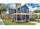 Charming two-story blue home featuring a welcoming wraparound porch and manicured front yard at 301 S Palmetto Ave, Sanford, FL 32771