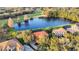 Expansive aerial view showcasing a beautiful home with a red tile roof by a serene lake and golf course at 3156 Winding Pine Trl, Longwood, FL 32779