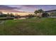 Scenic backyard view featuring a lush lawn, a tranquil lake, and a screened-in pool area, perfect for relaxation at 3156 Winding Pine Trl, Longwood, FL 32779