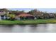 Picturesque backyard with a tranquil lake view, complemented by palm trees and a screened patio at 3156 Winding Pine Trl, Longwood, FL 32779