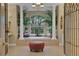 Luxurious bathroom featuring a soaking tub with a view of greenery and a decorative chandelier at 3156 Winding Pine Trl, Longwood, FL 32779