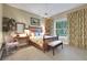 Warm bedroom with a decorative headboard, complemented by a desk, a large window, and soothing decor at 3156 Winding Pine Trl, Longwood, FL 32779