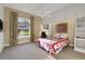 Comfortable bedroom with built-in shelves, a large window with decorative curtains, and a ceiling fan at 3156 Winding Pine Trl, Longwood, FL 32779