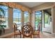 Dining area with a glass table set, large windows, and sliding door with pool view at 3156 Winding Pine Trl, Longwood, FL 32779