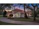 Beautiful two-story home with a red tile roof, well-manicured lawn, and circular driveway at 3156 Winding Pine Trl, Longwood, FL 32779