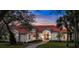 Elegant home featuring a red tile roof, arched entryway, manicured lawn, and lush landscaping, perfect for curb appeal at 3156 Winding Pine Trl, Longwood, FL 32779