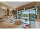 Bright living room with large sliding glass doors, offering views of the pool, lake, and landscaped backyard at 3156 Winding Pine Trl, Longwood, FL 32779