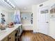 Bathroom with dual sinks, large mirror, a tub and shower combo, and wood floors at 3408 Idlegrove Ct, Orlando, FL 32822