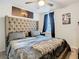 Bedroom with a large upholstered headboard, ceiling fan, and decorative artwork at 3408 Idlegrove Ct, Orlando, FL 32822