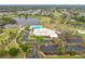 Aerial view of the clubhouse with pool, parking, golf course, and a beautiful lake with water fountain at 3408 Idlegrove Ct, Orlando, FL 32822