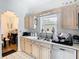 Kitchen area featuring ample counter space, light wood cabinets, a stainless steel sink, and a dishwasher at 3408 Idlegrove Ct, Orlando, FL 32822
