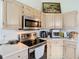 Kitchen area featuring light wood cabinets, modern appliances, and ample counter space at 3408 Idlegrove Ct, Orlando, FL 32822