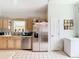 Spacious kitchen featuring white tile floors, light wood cabinetry, and stainless steel appliances at 3408 Idlegrove Ct, Orlando, FL 32822