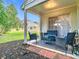 Covered patio with black wicker seating, adjacent to grass lawn and mulch bed at 3408 Idlegrove Ct, Orlando, FL 32822