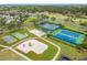 Aerial view of tennis courts, playground, bocce ball, and a residential community in a serene setting at 3408 Idlegrove Ct, Orlando, FL 32822