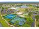 Aerial view of tennis courts, playground, bocce ball, lake, and golf course in a lush green community at 3408 Idlegrove Ct, Orlando, FL 32822
