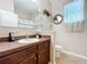Charming bathroom with dark wood cabinets, decorative mirror and bright lighting at 3620 Chandler Estates Dr, Apopka, FL 32712