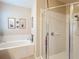 Bright bathroom featuring a soaking tub, a glass shower, and neutral colored tiles at 3620 Chandler Estates Dr, Apopka, FL 32712