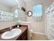 Charming bathroom with dark wood cabinets, decorative mirror, and bathtub at 3620 Chandler Estates Dr, Apopka, FL 32712