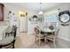 Dining area with round glass table and upholstered chairs with decorative mirror and window at 3620 Chandler Estates Dr, Apopka, FL 32712