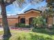 Inviting single-Gathering home showcasing an arched entryway and lush, colorful landscaping at 3620 Chandler Estates Dr, Apopka, FL 32712